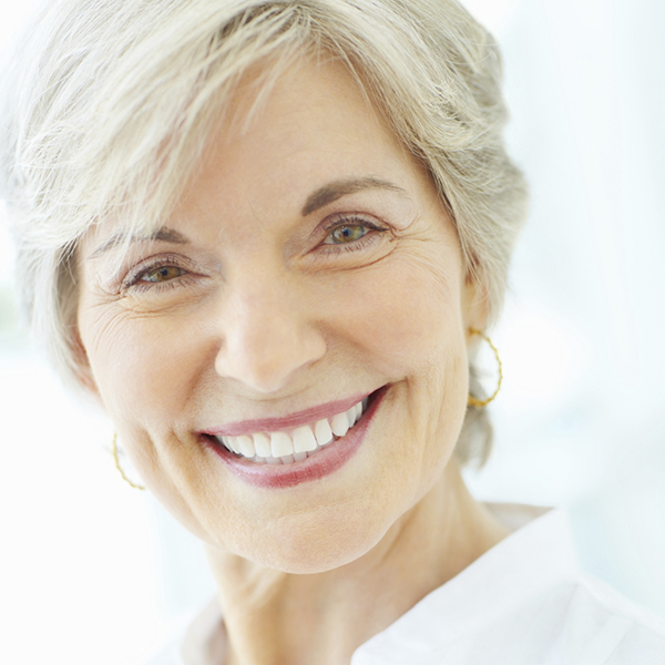 Detail shot of a happy mature woman giving you a cute smile